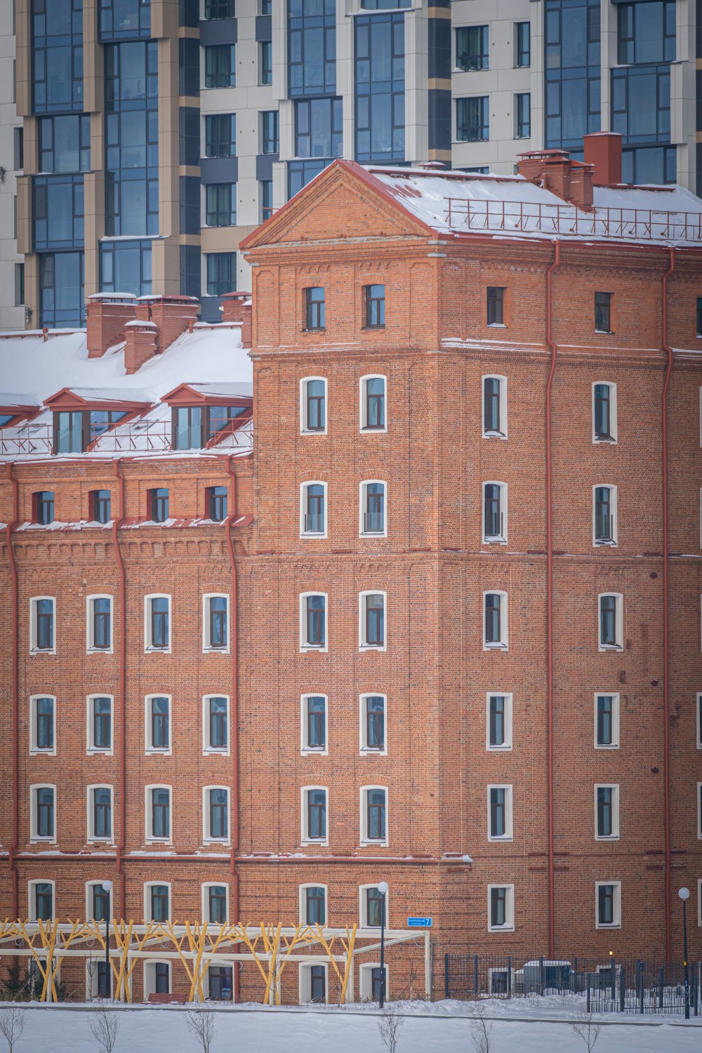 um edifício de tijolo vermelho com neve no telhado