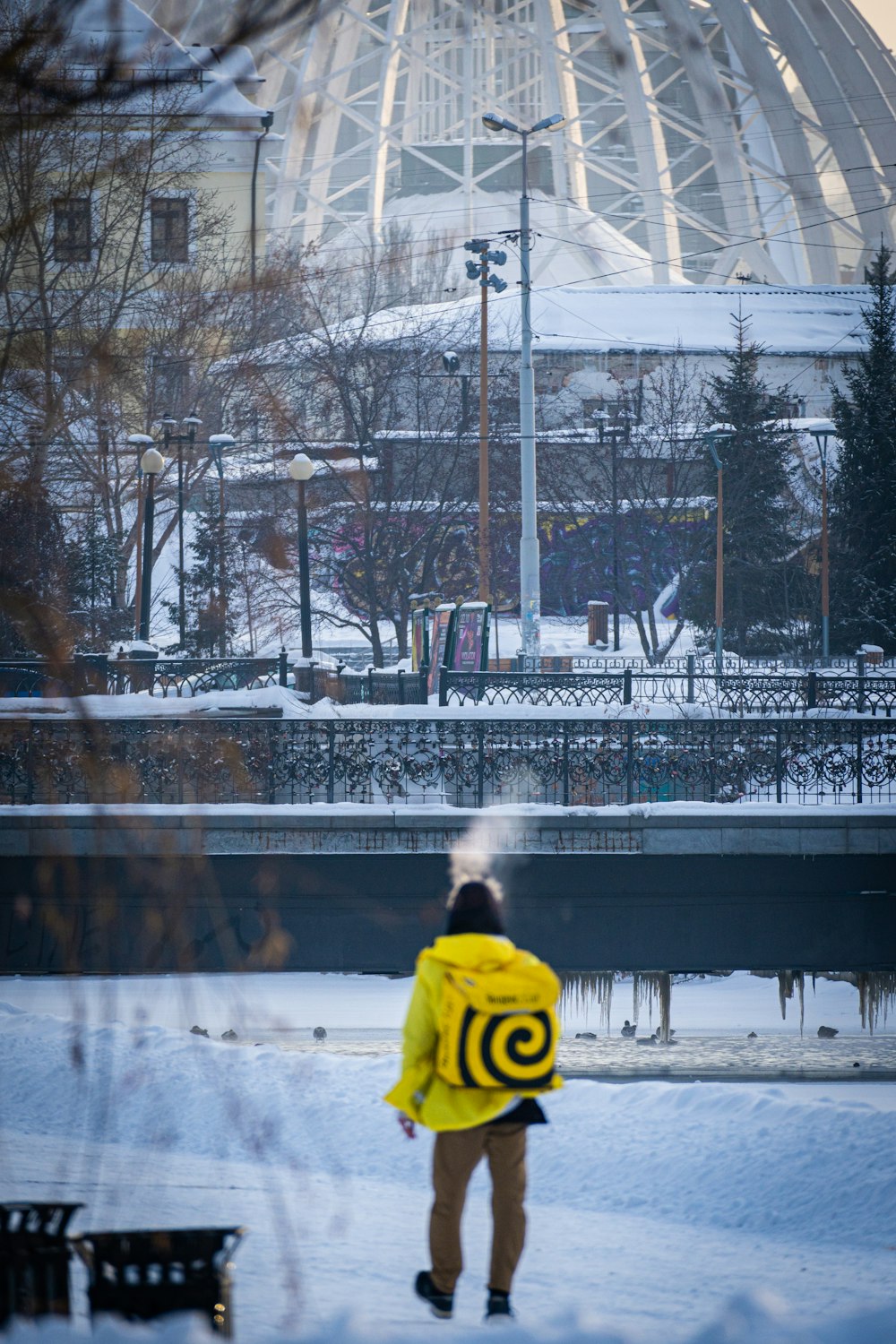 Una persona con una chaqueta amarilla parada en la nieve