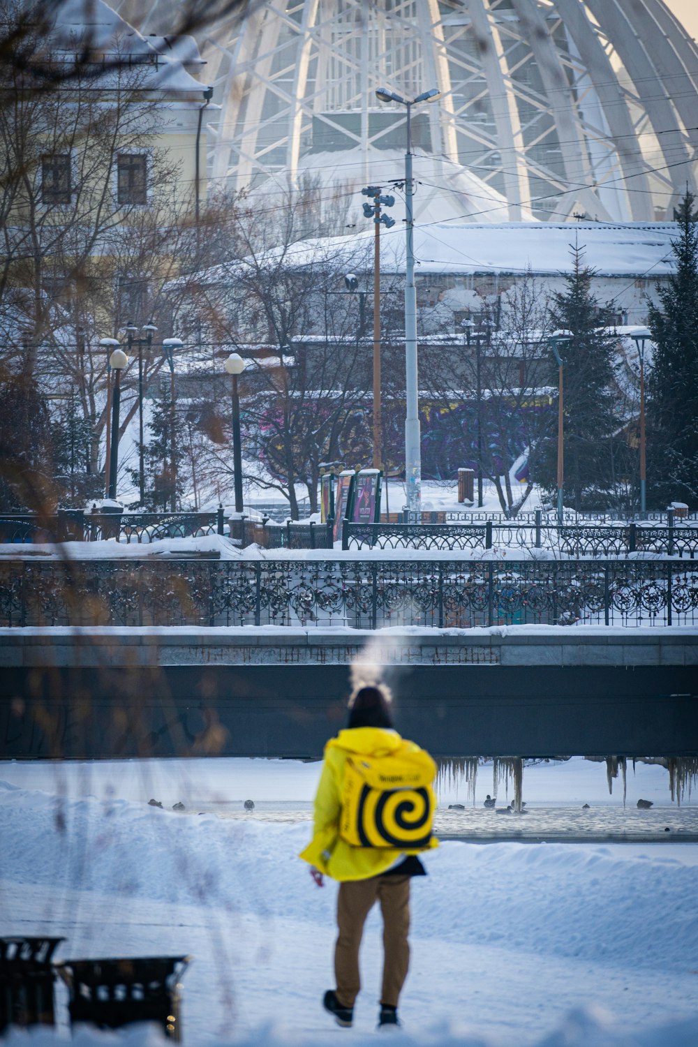 Eine Person in einer gelben Jacke, die im Schnee steht