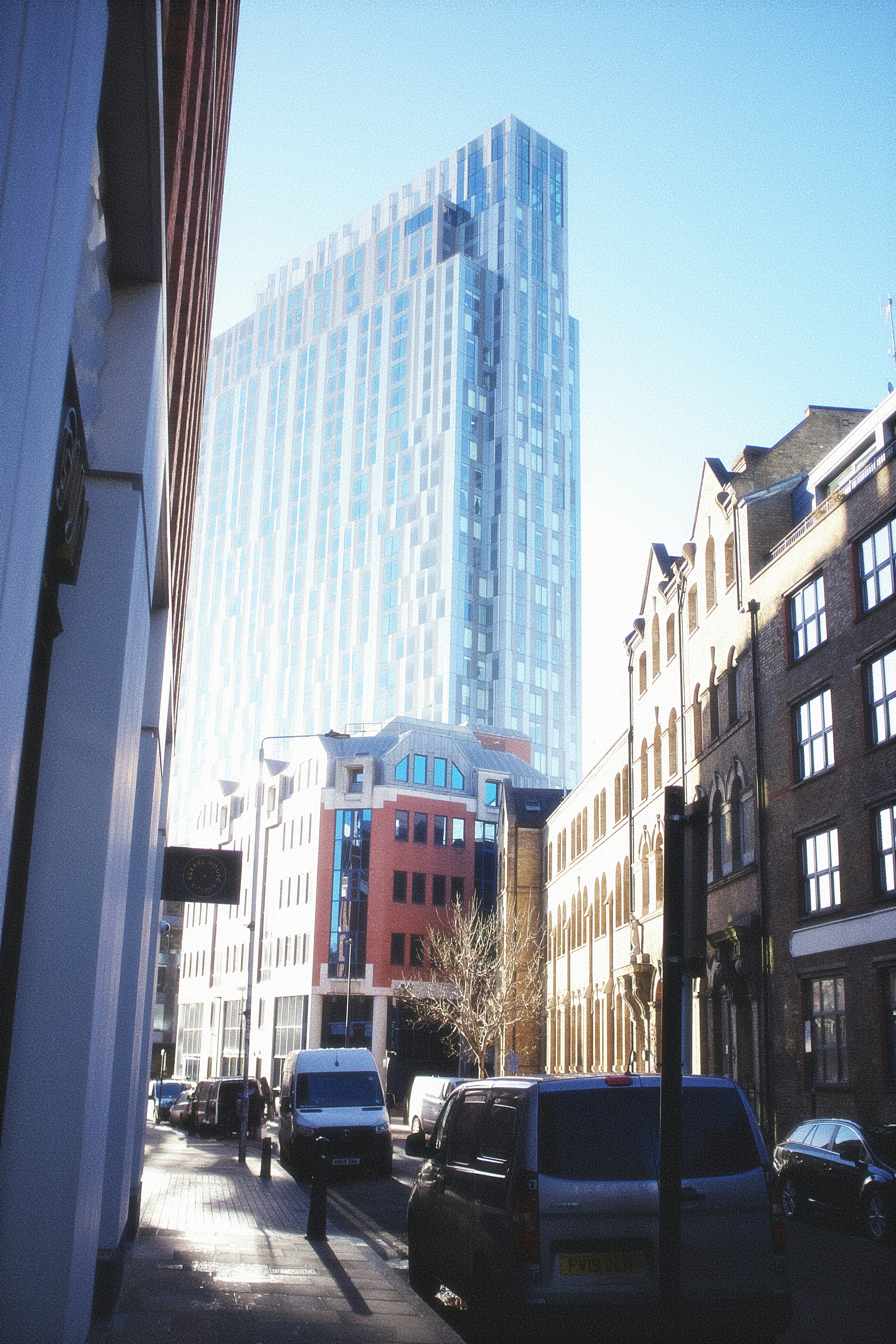 a city street lined with tall buildings and parked cars