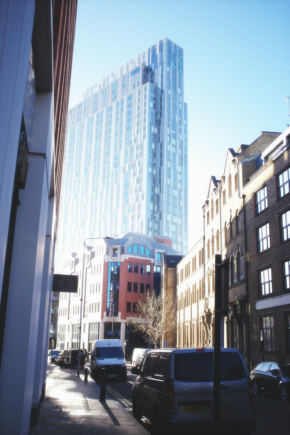 a city street lined with tall buildings and parked cars