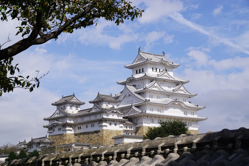 a tall white building sitting on top of a lush green field