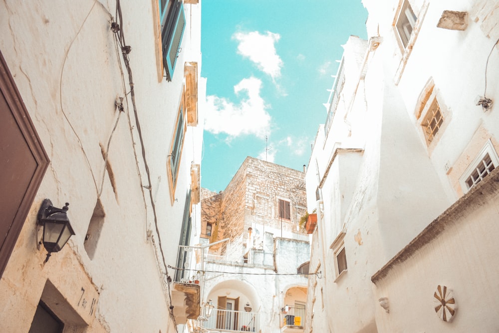 a narrow alleyway in a city with a sky background