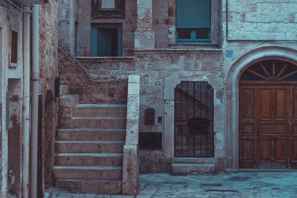 a stone building with a wooden door and stairs