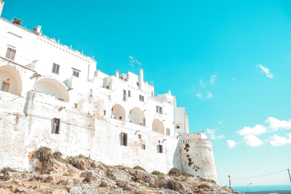 a white building on a hill with a blue sky in the background