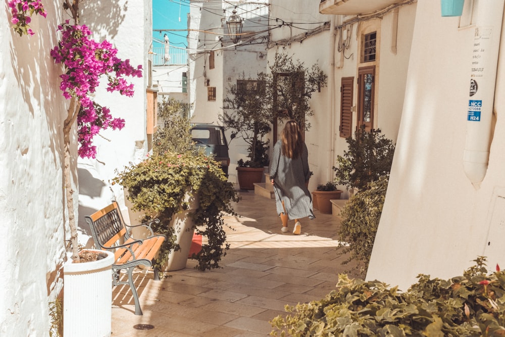 a woman walking down a narrow alley way