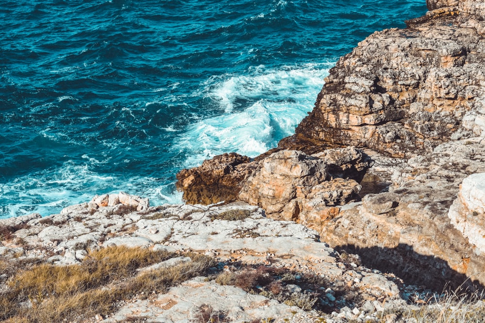 a person standing on a cliff overlooking the ocean