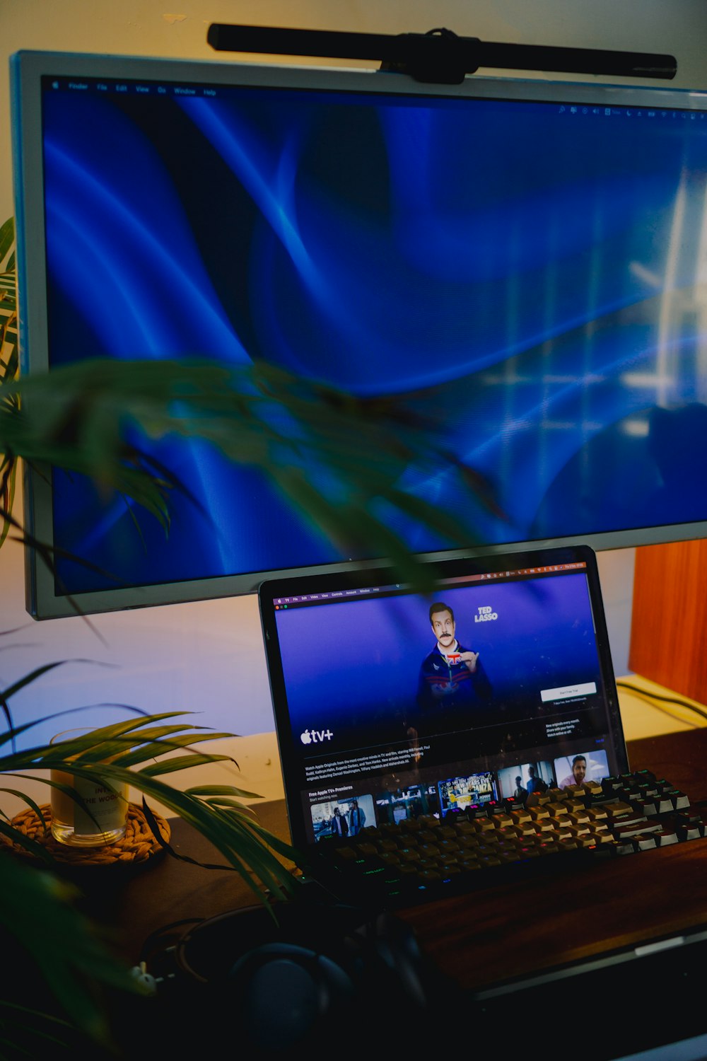 a flat screen tv sitting on top of a laptop computer monitor and keyboard