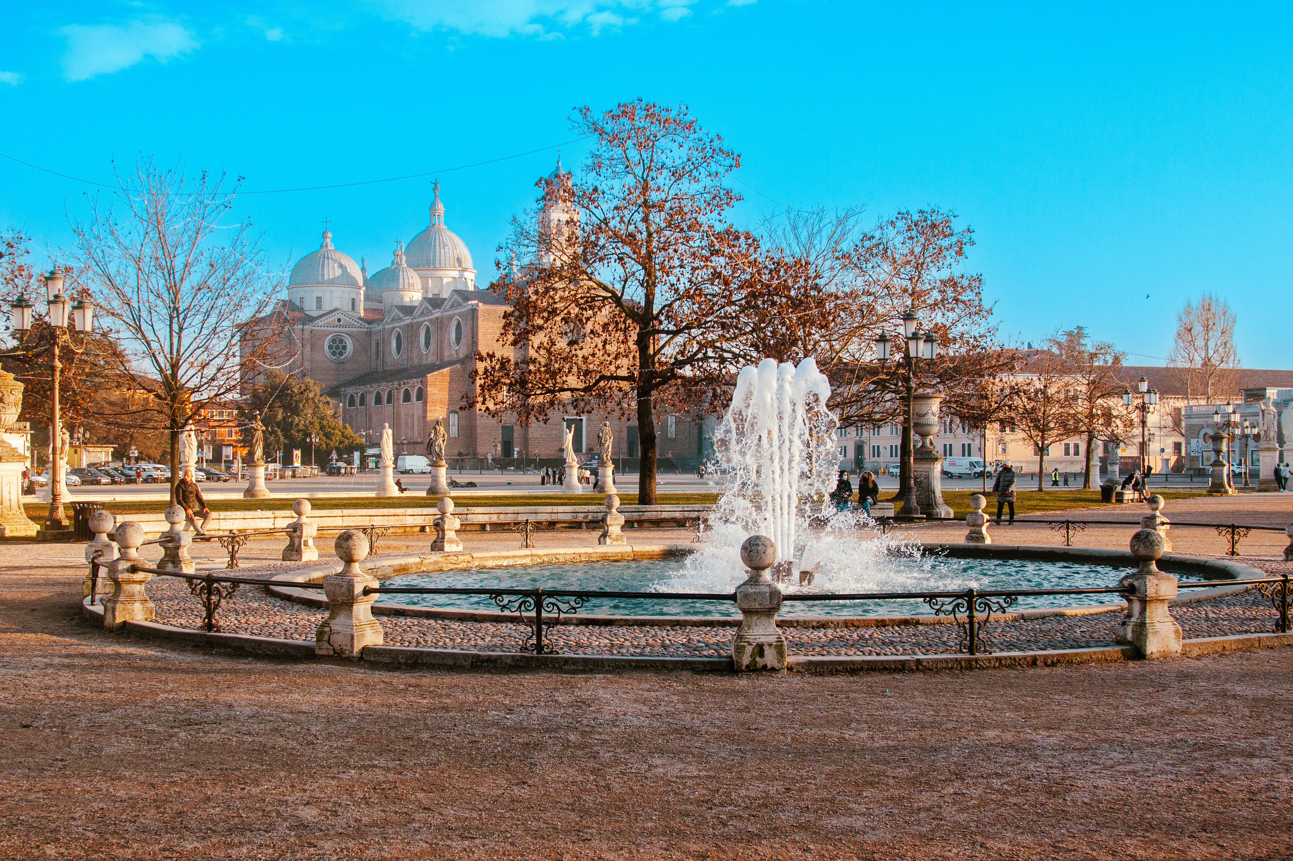 a fountain in a park with a building in the background