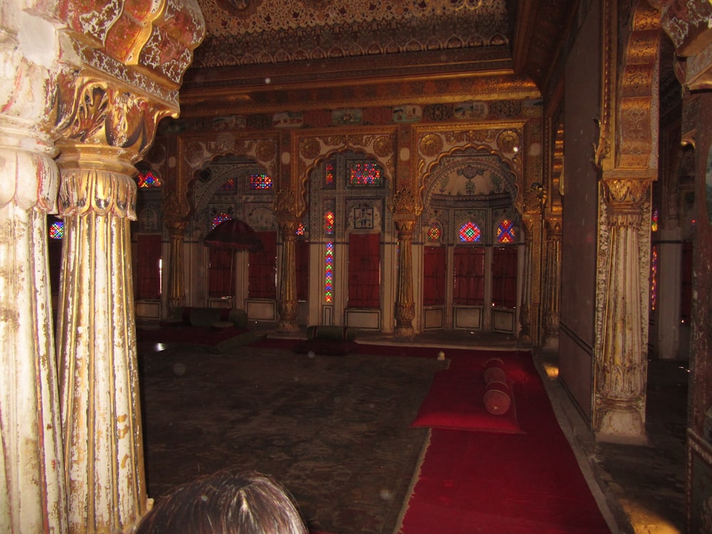 a large room with a red carpet and columns