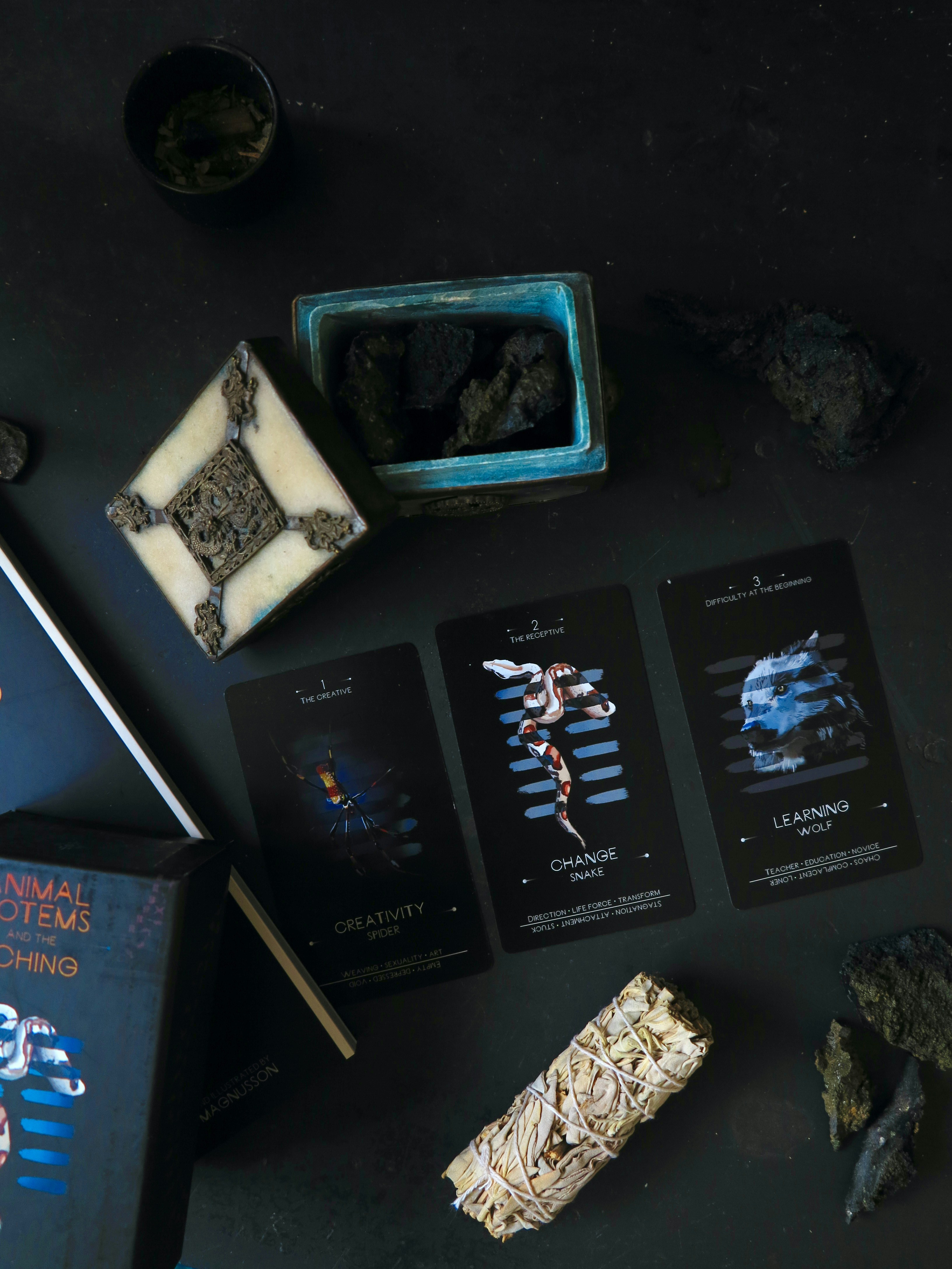 Tarot cards, runes, and divination tools spread on dark surface