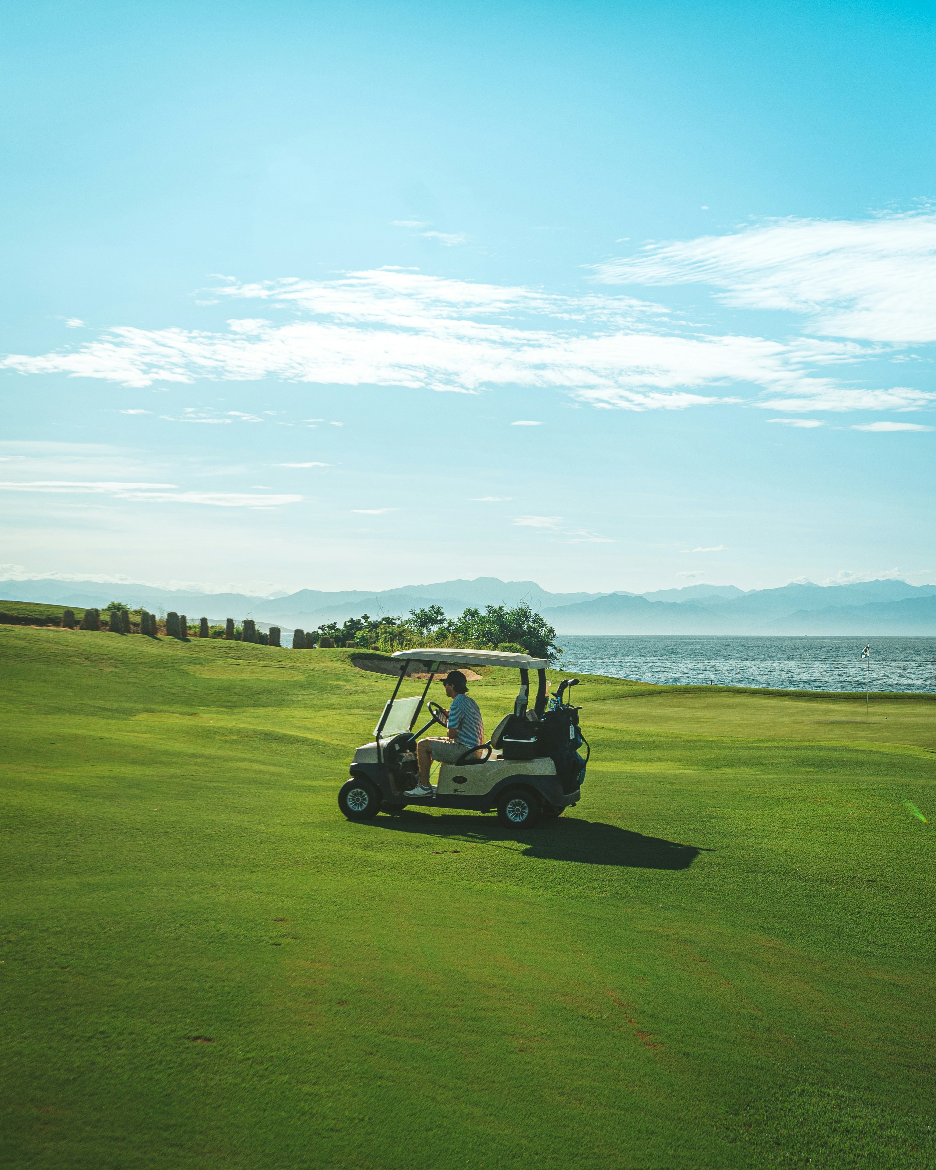 a man driving a golf cart on a golf course