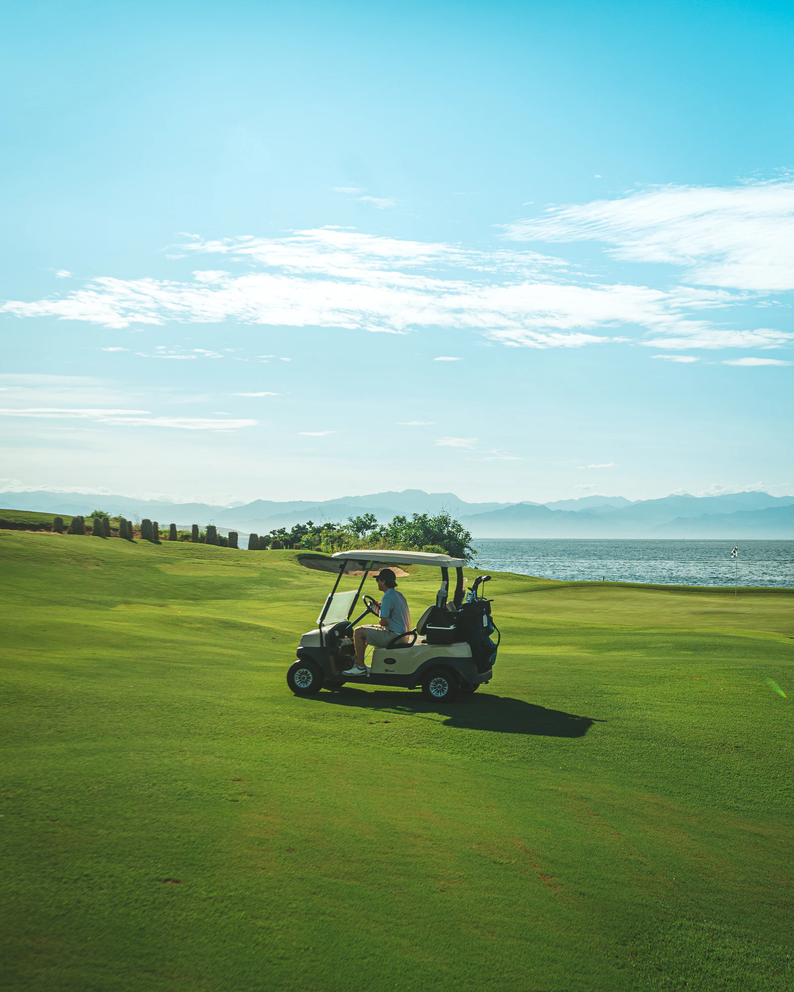 A man driving a golf cart along a fairway at Punta Mita, Nayarit