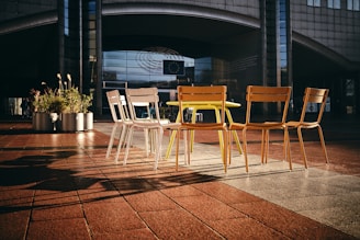 a group of four chairs sitting on top of a tiled floor