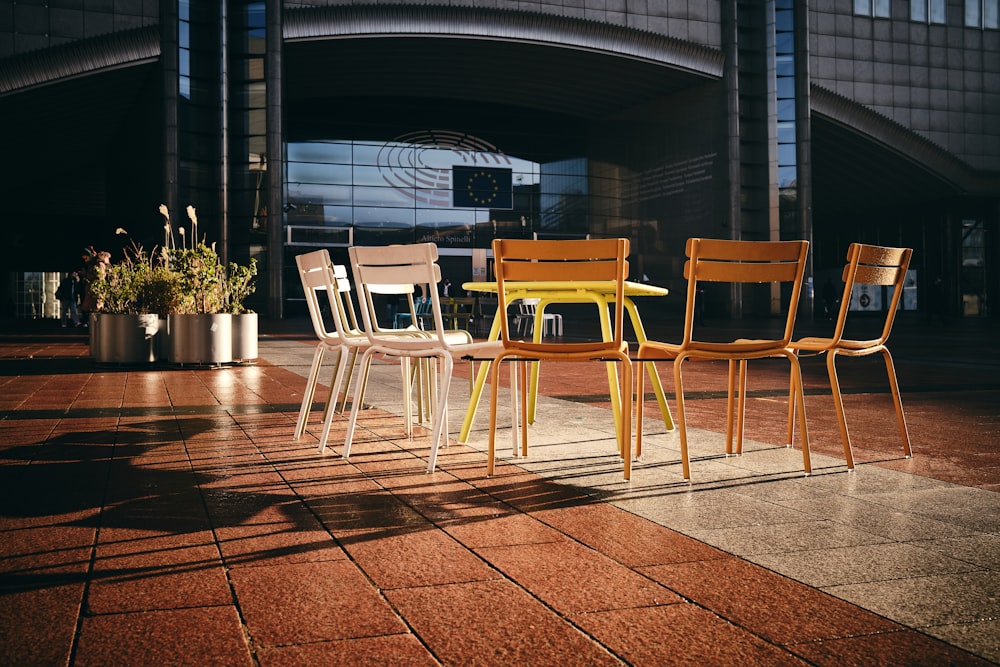 a group of four chairs sitting on top of a tiled floor