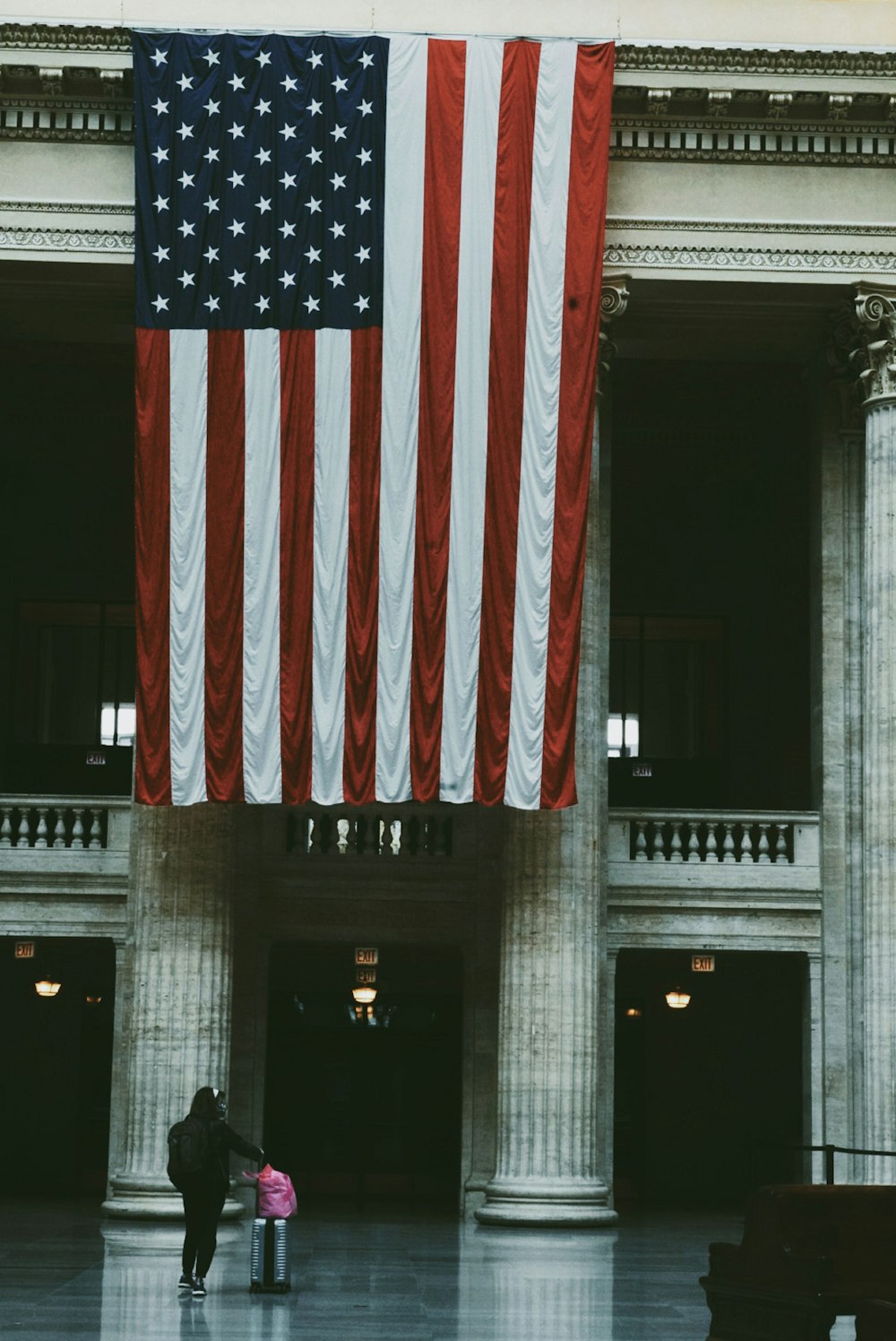 a large american flag hanging from the side of a building