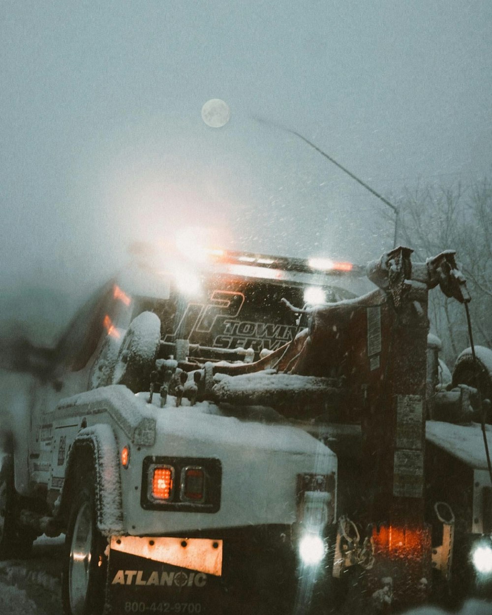 a truck driving down a snow covered road