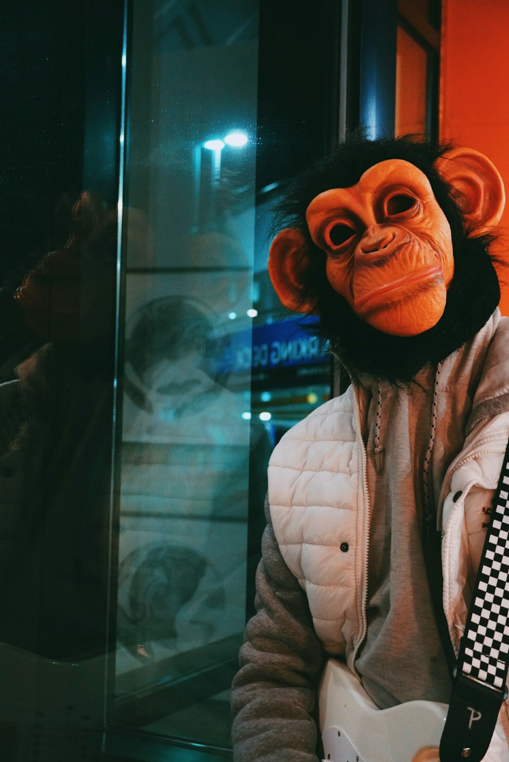 a monkey wearing a jacket and tie holding a guitar