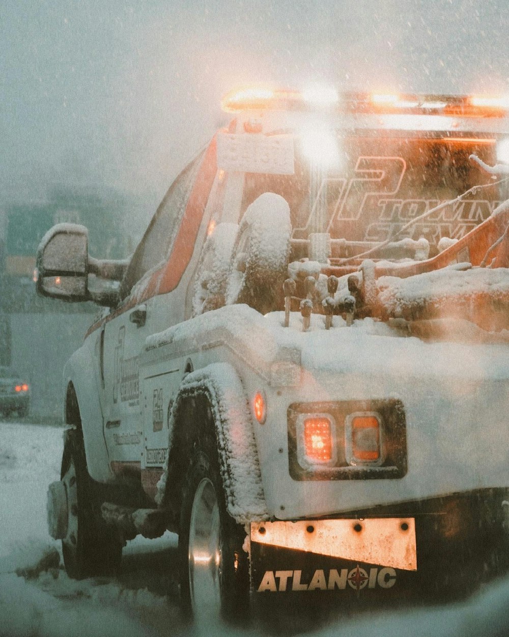 a white truck driving down a snow covered road