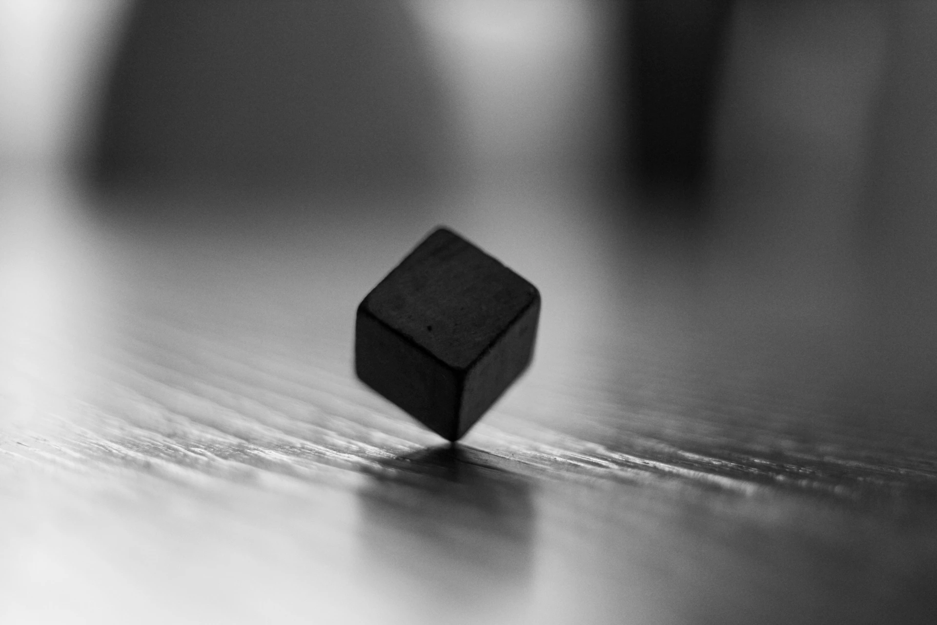 a black cube sitting on top of a wooden table