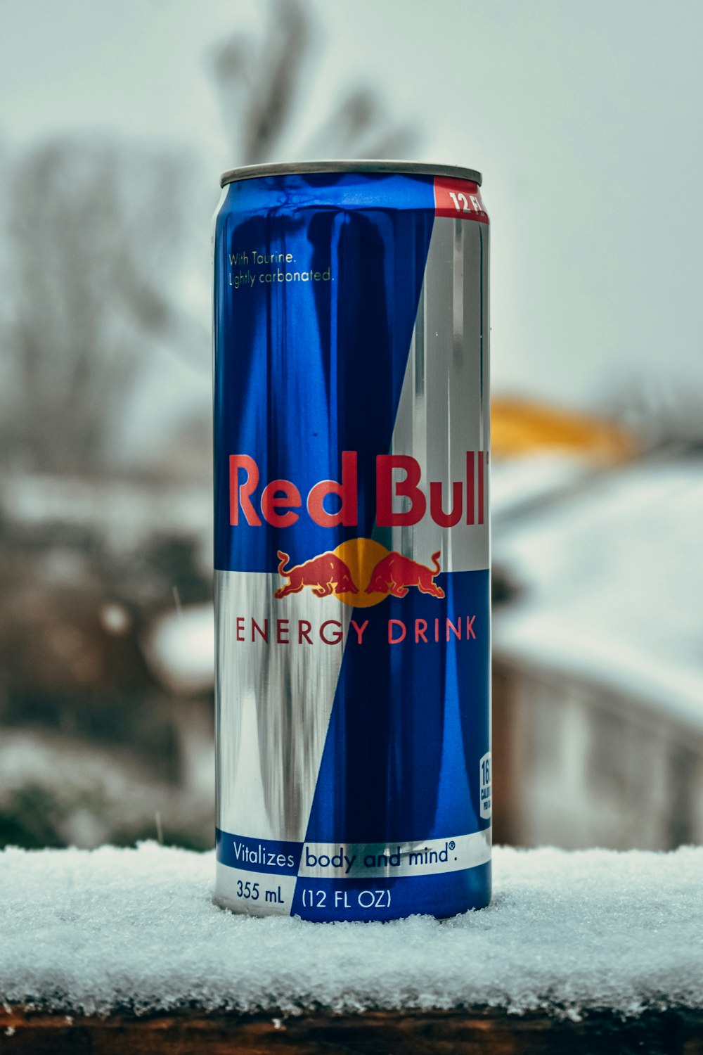 a can of red bull energy drink sitting in the snow