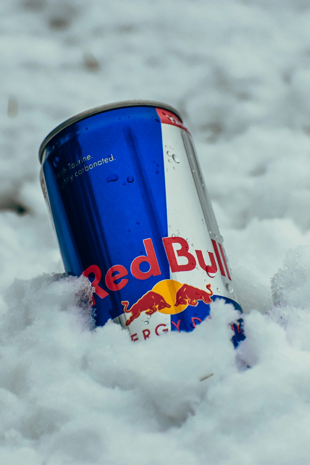 a can of red bull in the snow