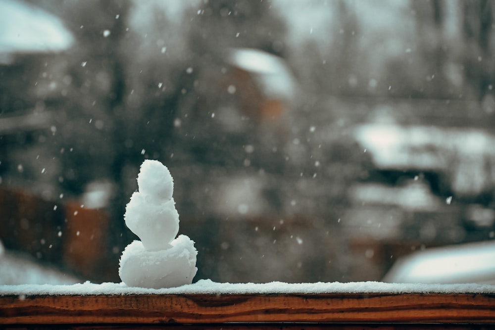 a snowman sitting on top of a window sill