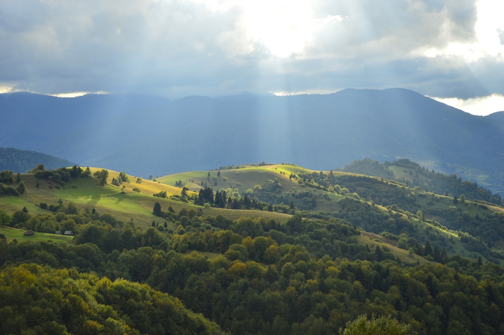 the sun shines through the clouds over the mountains