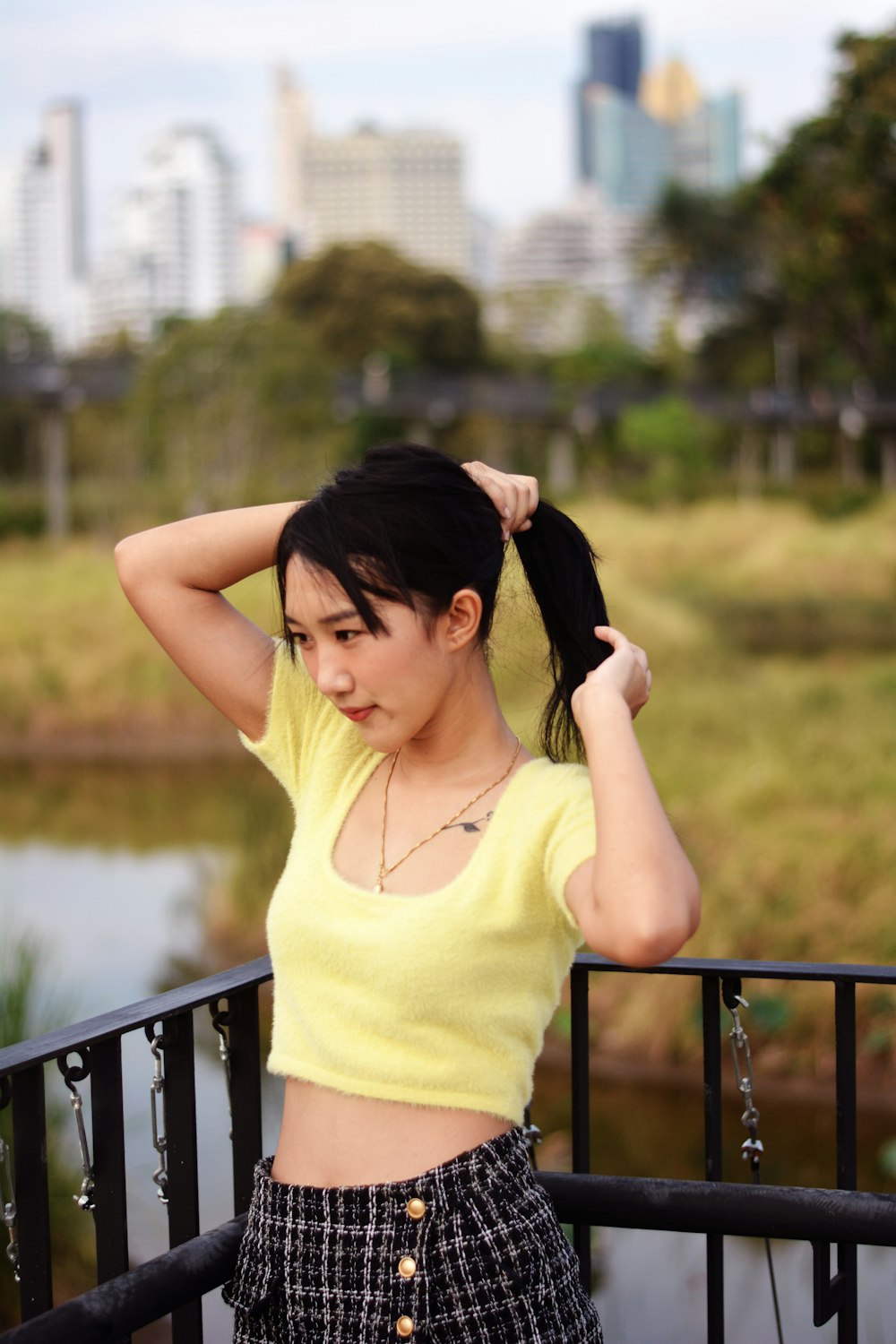 a woman in a yellow shirt is holding her hair