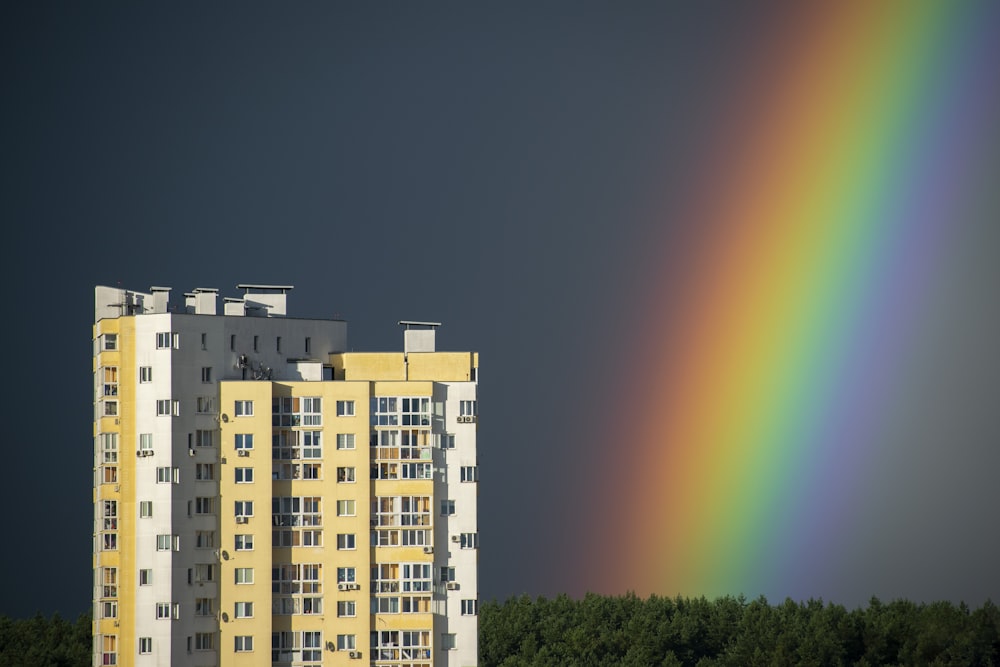 Un edificio alto con un arco iris en el fondo