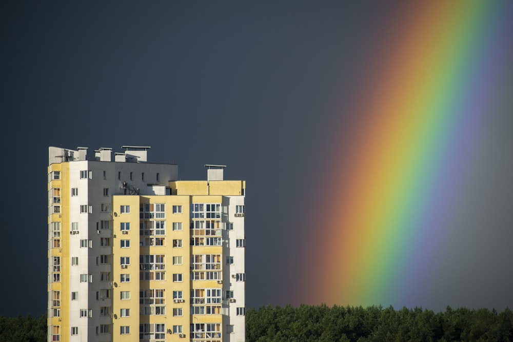 a tall building with a rainbow in the background