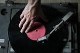 a person's hand on top of a record player