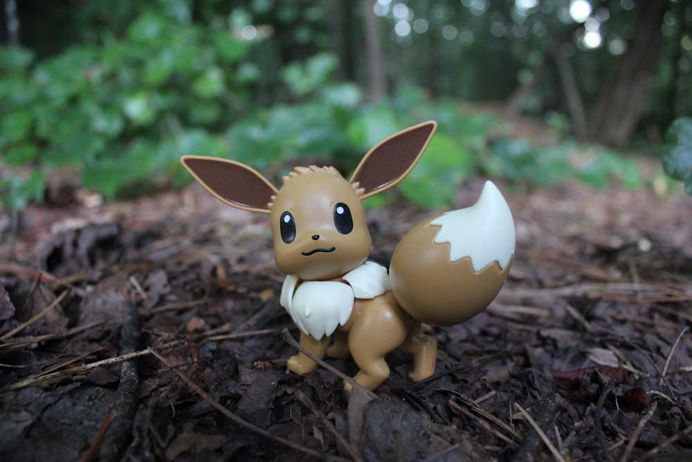 Una pequeña estatuilla de un Pokémon sentado en el suelo