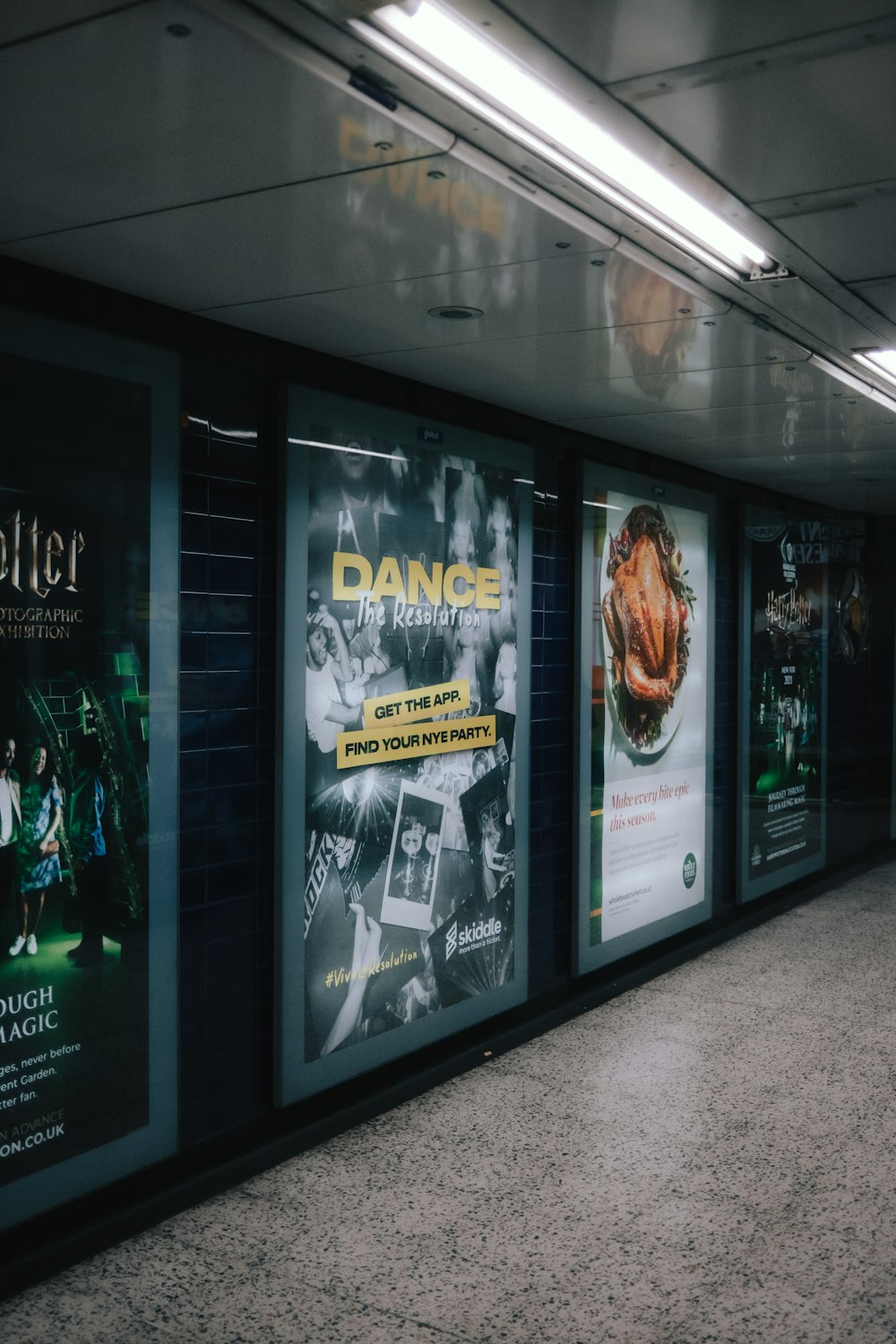 une station de métro avec des affiches sur le mur