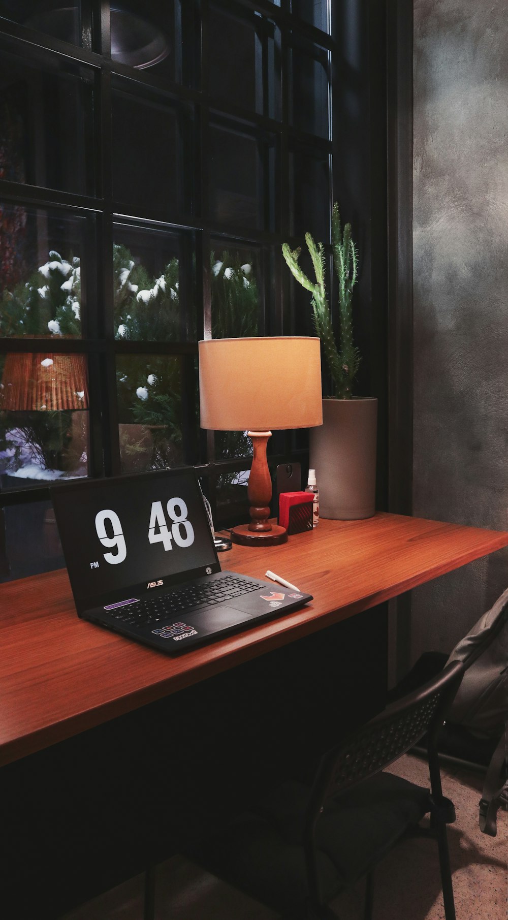 a desk with a laptop and a lamp on it