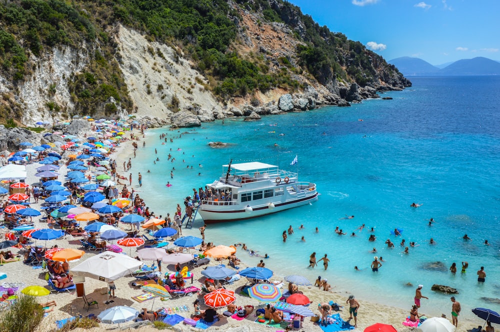 a group of people on a beach with a boat in the water