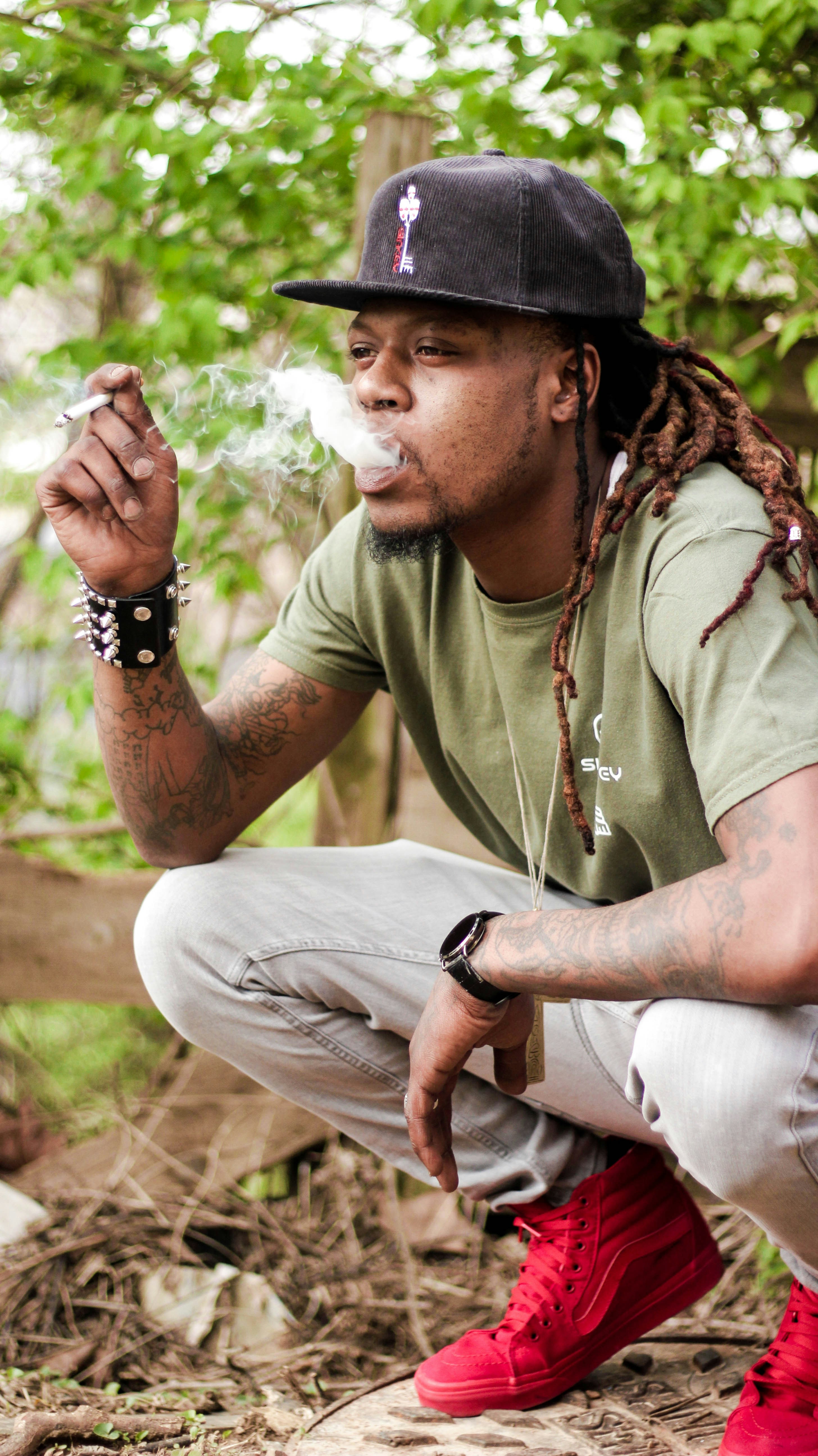 a man with dreadlocks smoking a cigarette