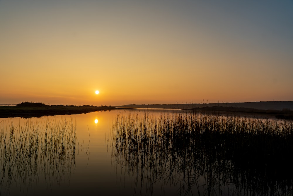 the sun is setting over a body of water