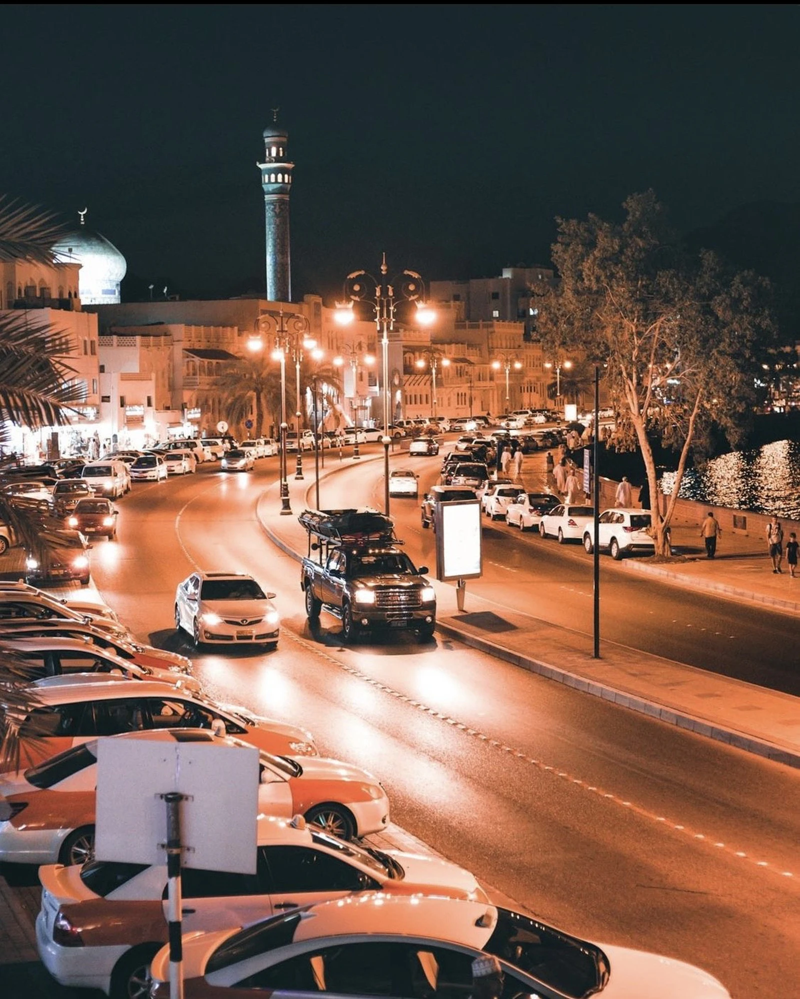 Night traffic moving through a lit boulevard in Muscat