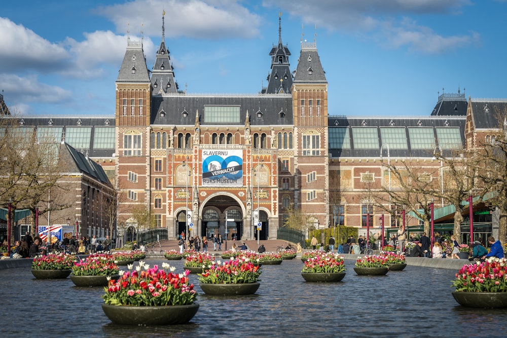 a large building with a lot of flowers in front of it