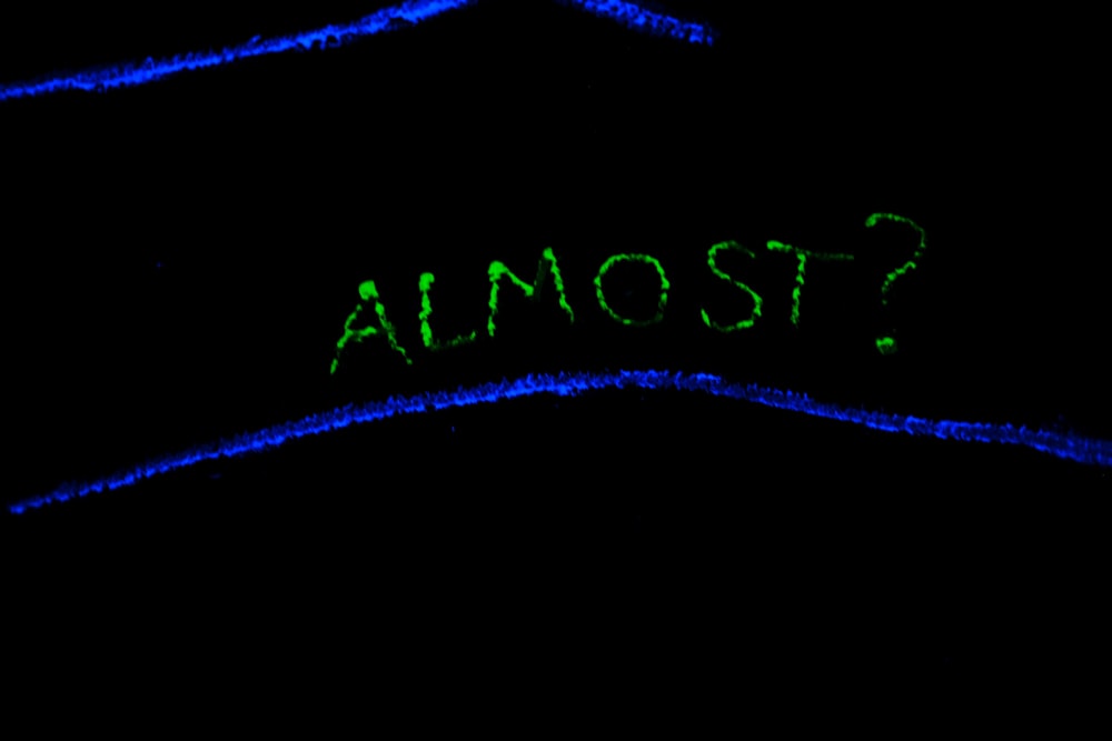 a close up of the word almost written in green