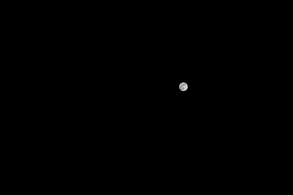 the moon is seen through the dark sky