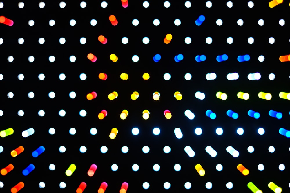 a black background with multicolored lights in the dark