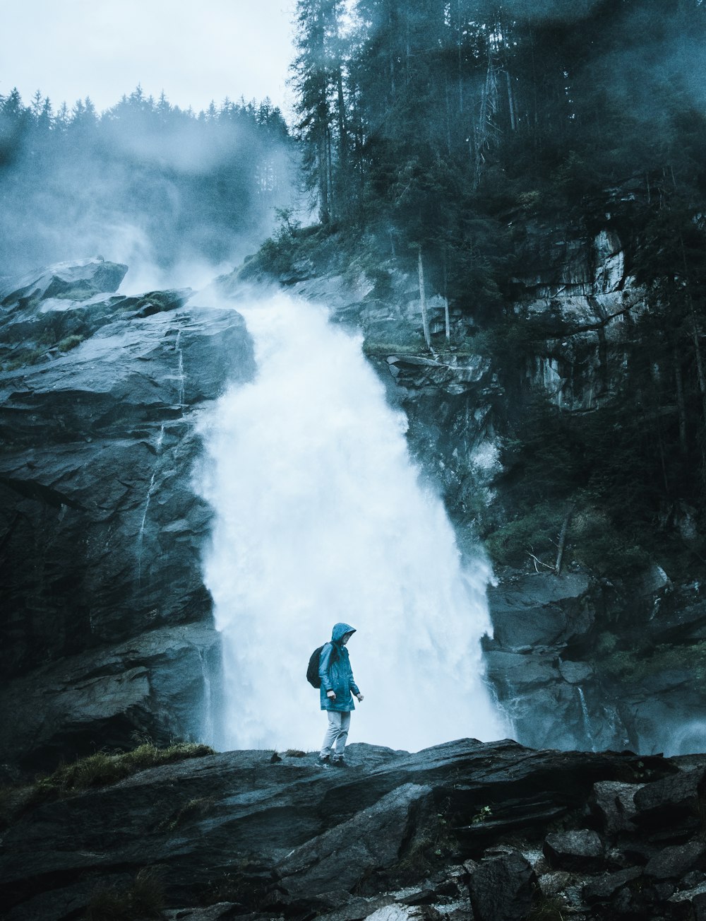 une personne debout devant une cascade