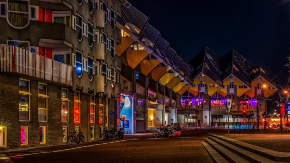 a row of multicolored buildings on a street at night