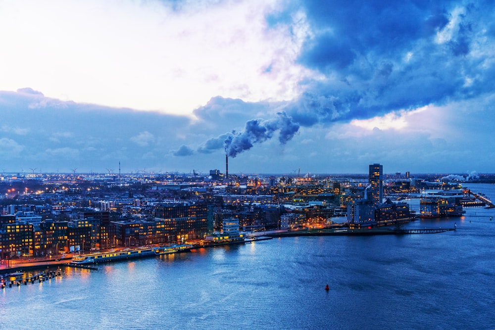 a view of a city at night with a lot of smoke coming out of the