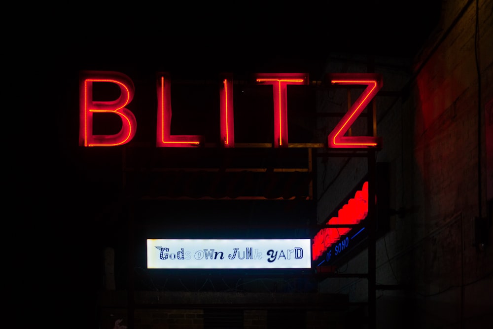 a neon sign is lit up in the dark