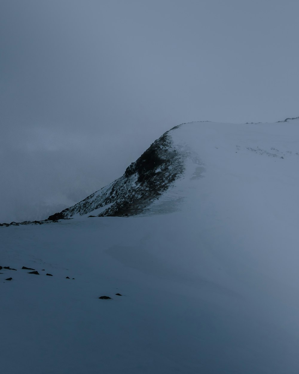 a mountain covered in snow with a sky background