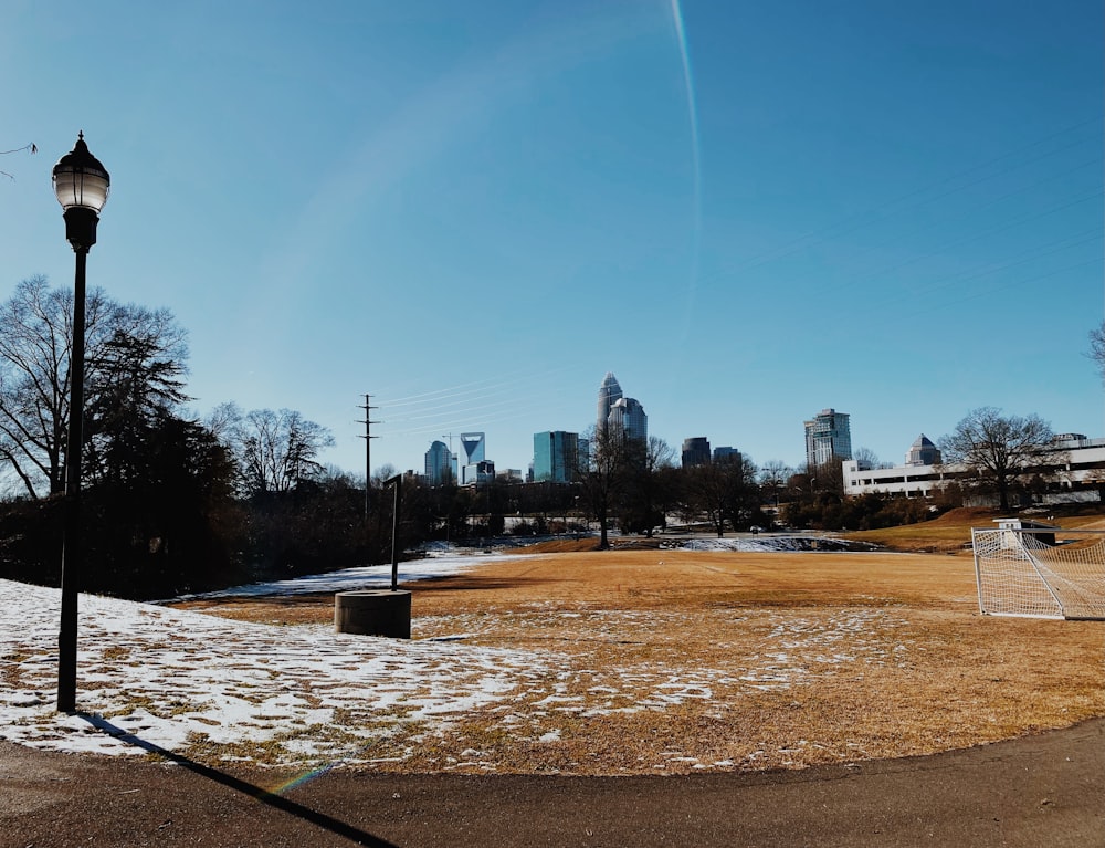 a park with a lamp post and snow on the ground