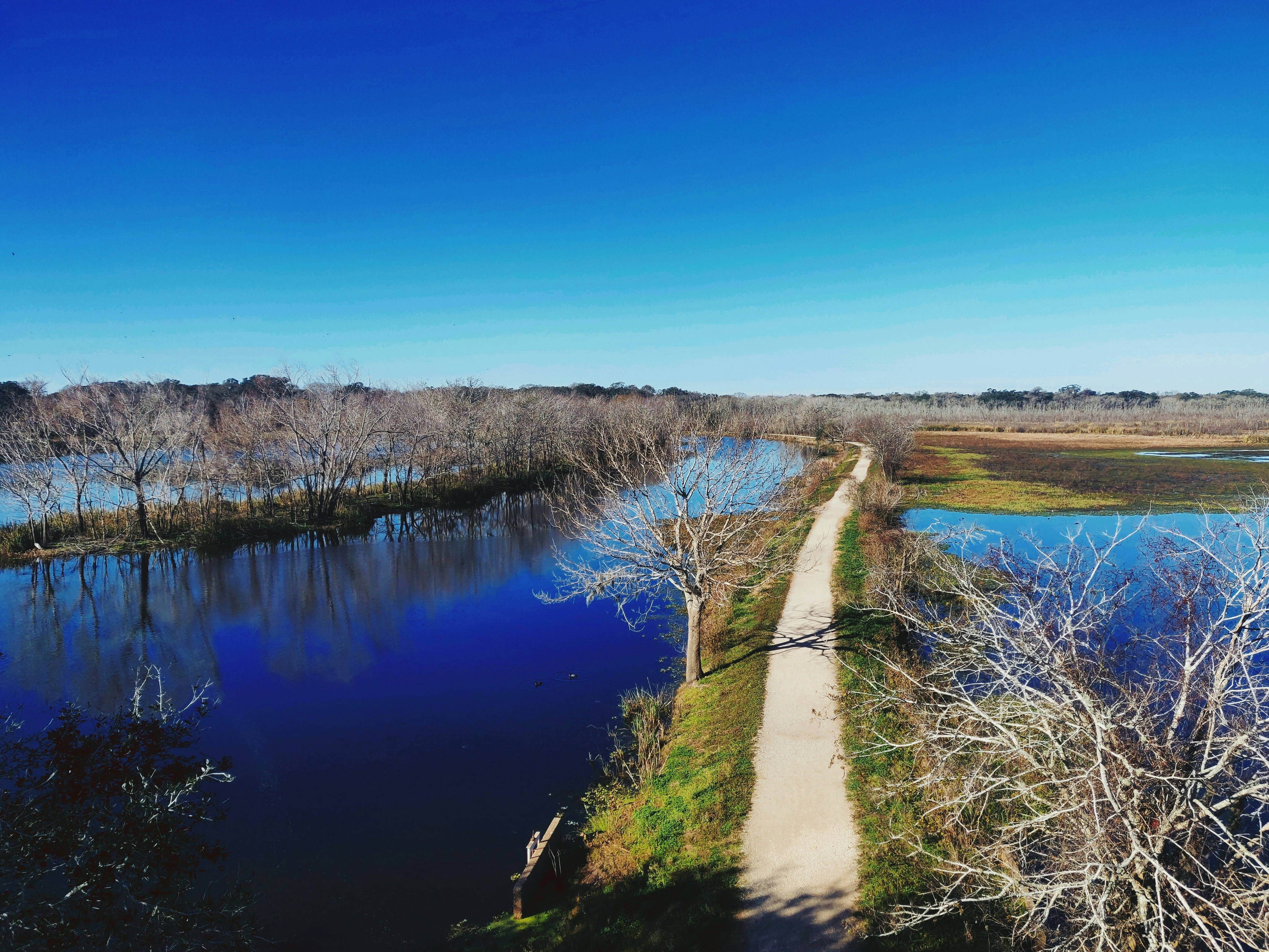 a dirt path next to a body of water